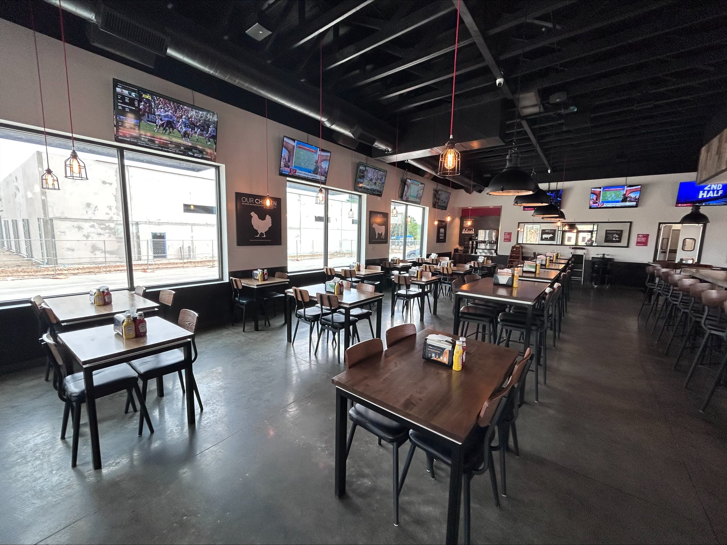 Interior of Banera Oaks with Dark Wooden tables, polished concrete floors, and plenty of TVs to