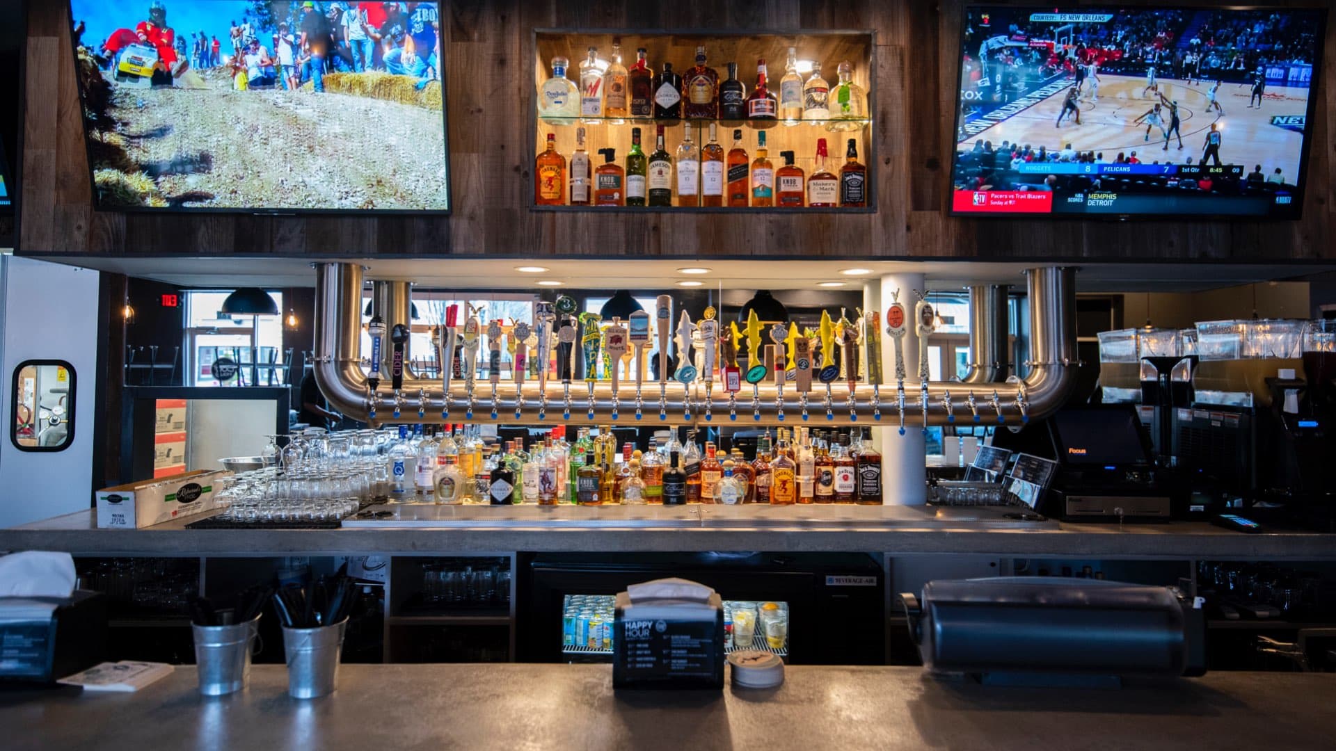 Spacious bar area featuring dozens of taps, premium spirits, and wall-mounted TVs for game day viewing.