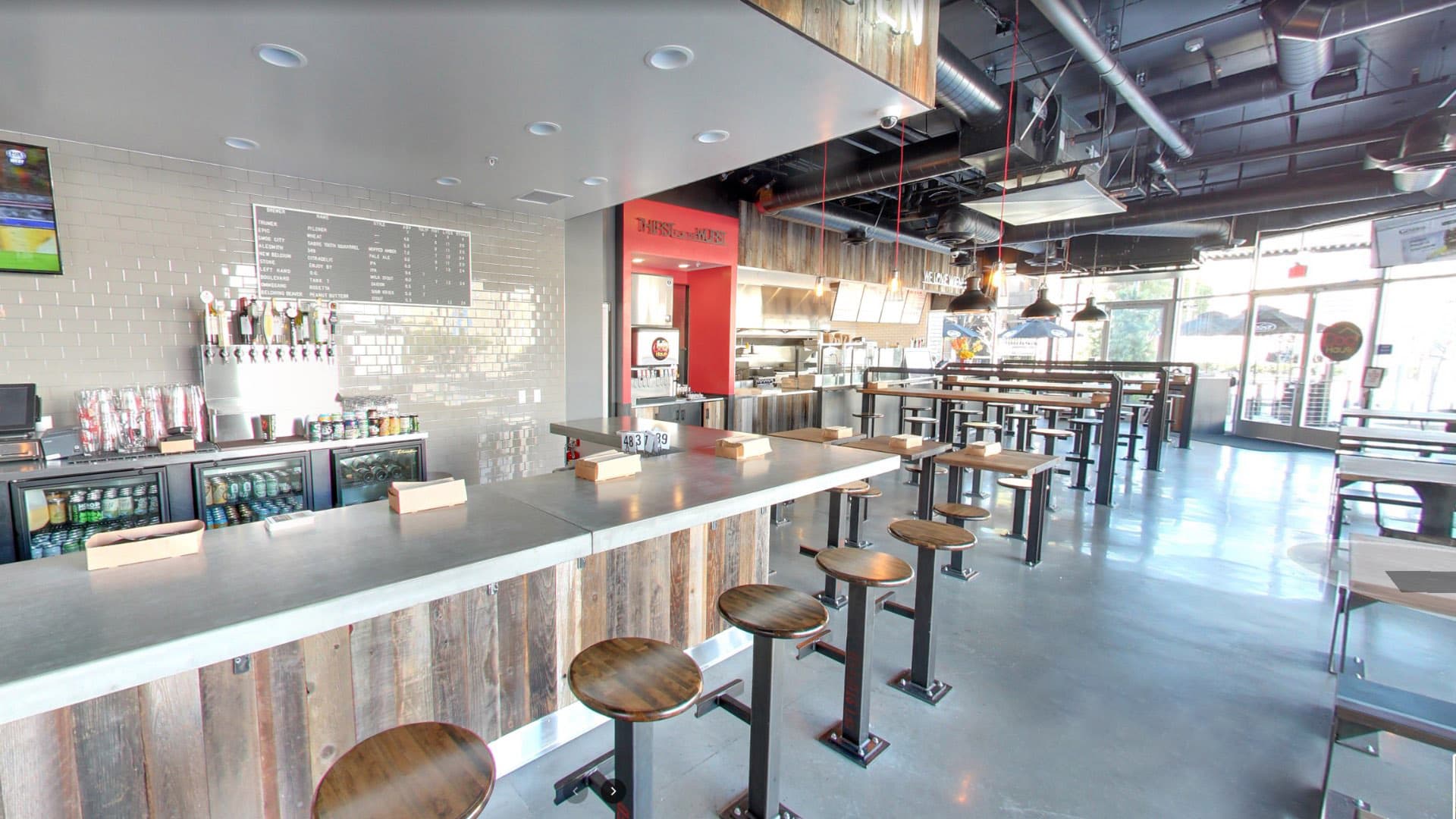 Interior bar at Dog Haus Long Beach featuring multiple beer taps, liquor display, and rustic wood finishes